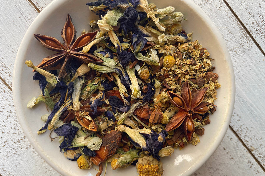 Bowl of dried berry tea leaves with star anise and blue blossoms