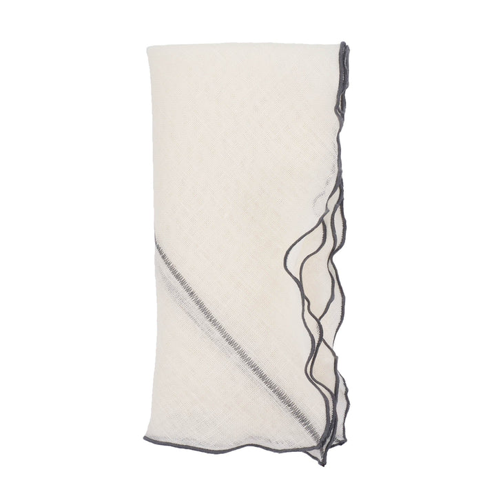 Off-white linen napkin with charcoal stitched edge and ruffled border, folded