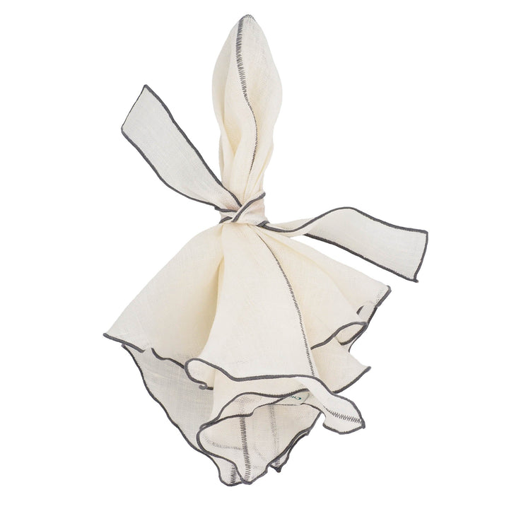 Off-white linen napkin tied with a ribbon and charcoal ruffled trim