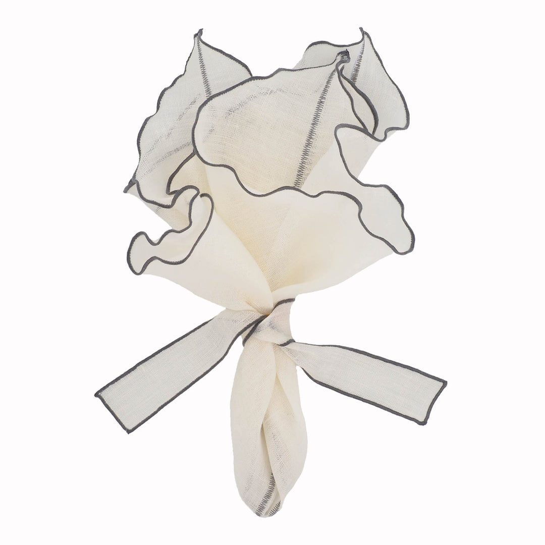 Off-white linen napkin tied bundle with charcoal ruffled border and trim