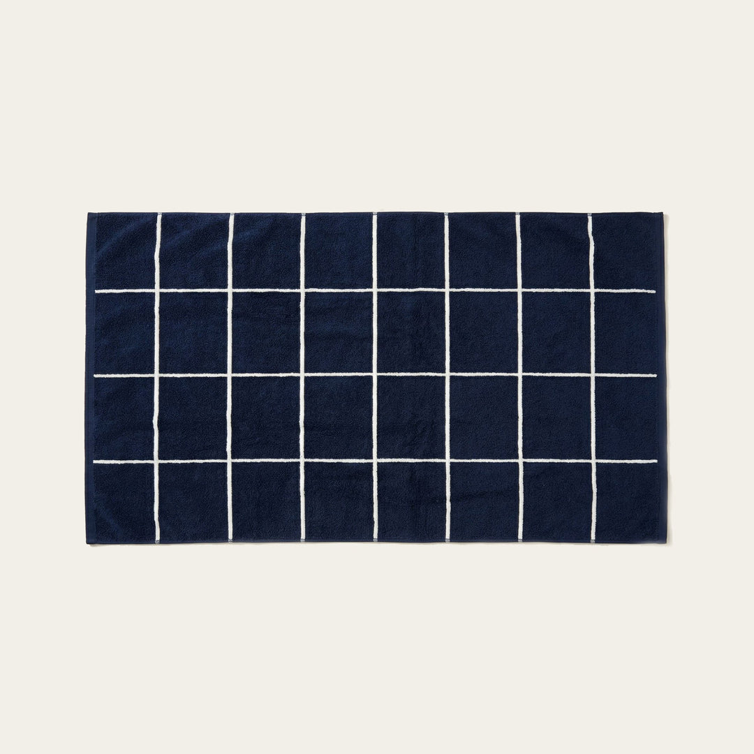 Navy and white cotton towel with a grid pattern of thin white stripes.