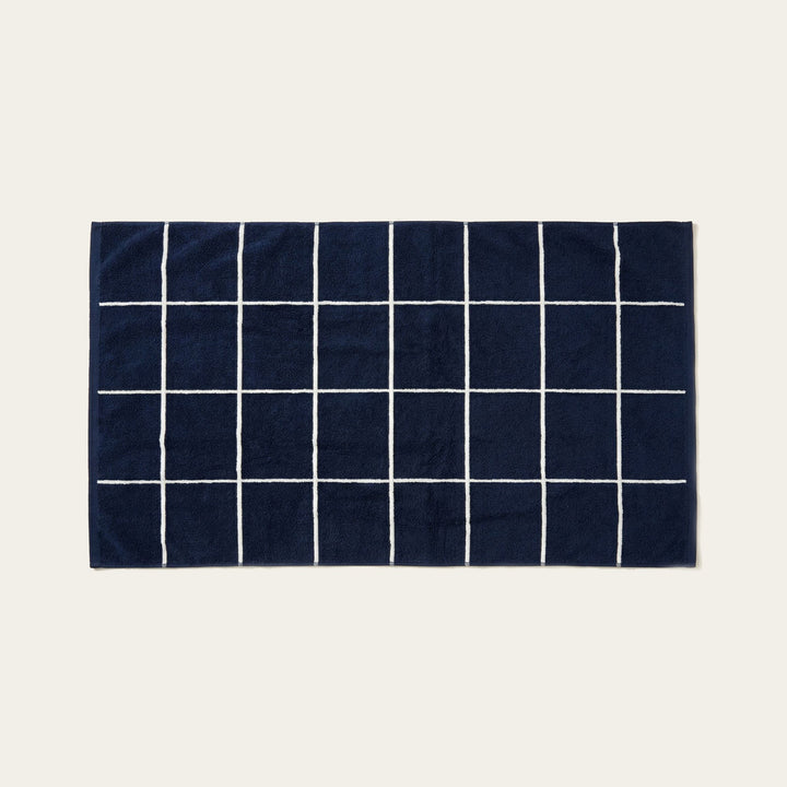 Navy and white cotton towel with a grid pattern of thin white stripes.
