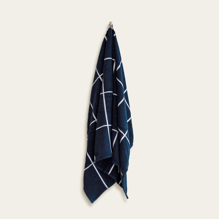 Navy and white cotton bath towel, folded with diagonal stripe line design.