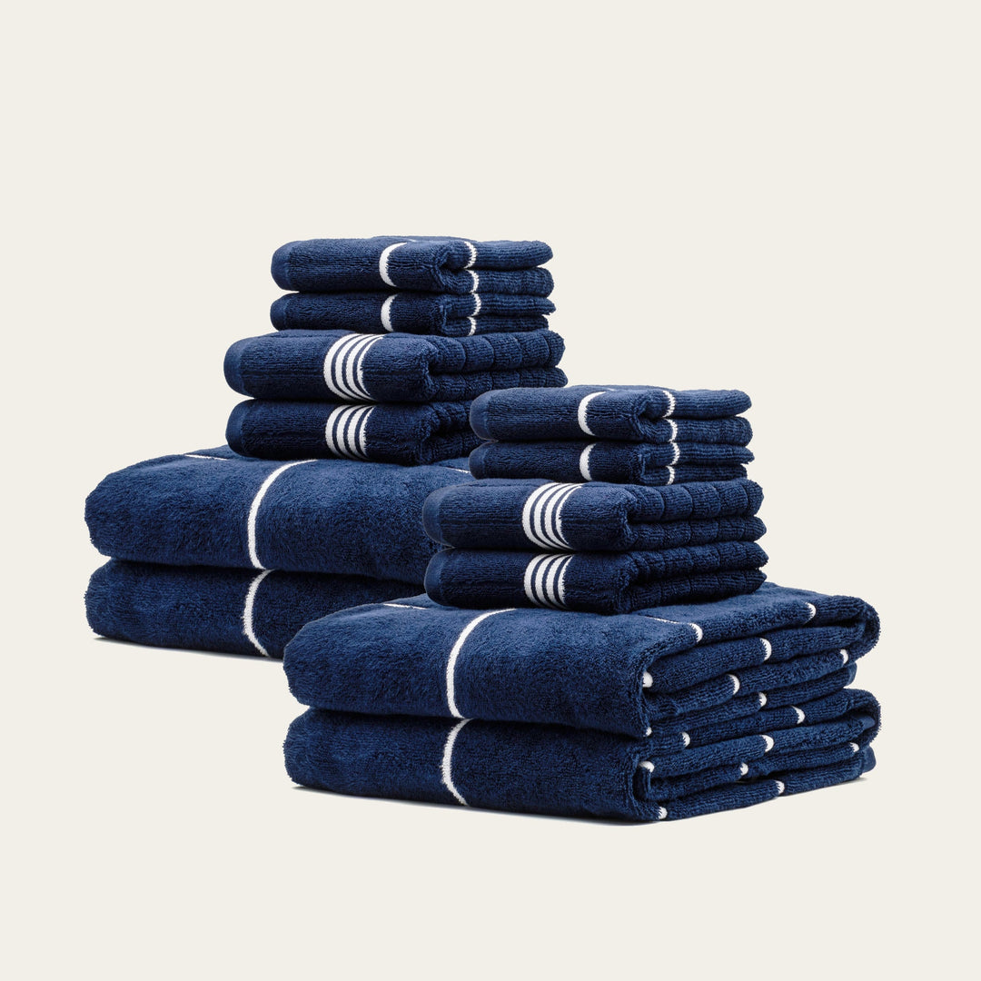 Assorted stack of navy cotton towels with white stripe detailing