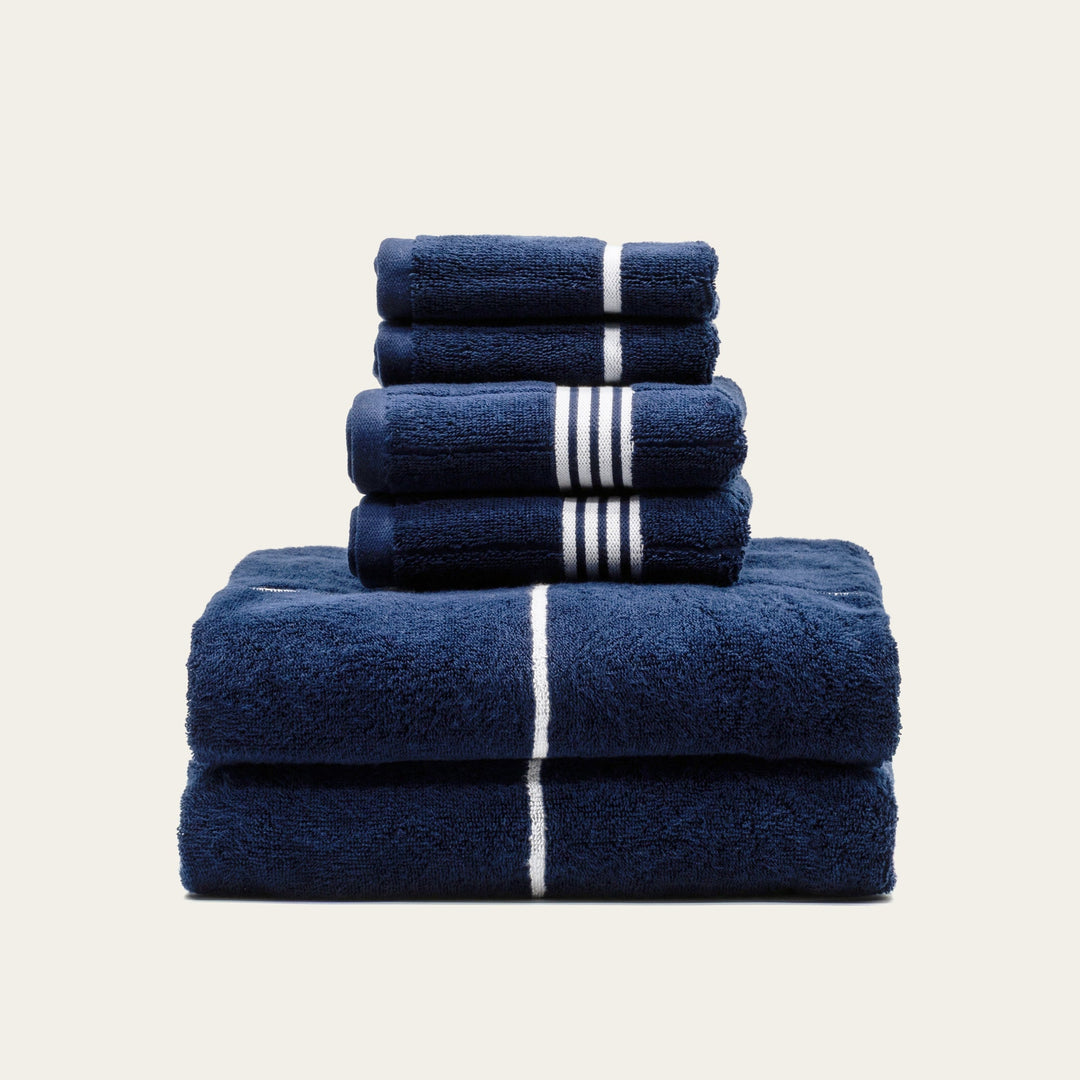 Stack of navy cotton towels with white stripe accents