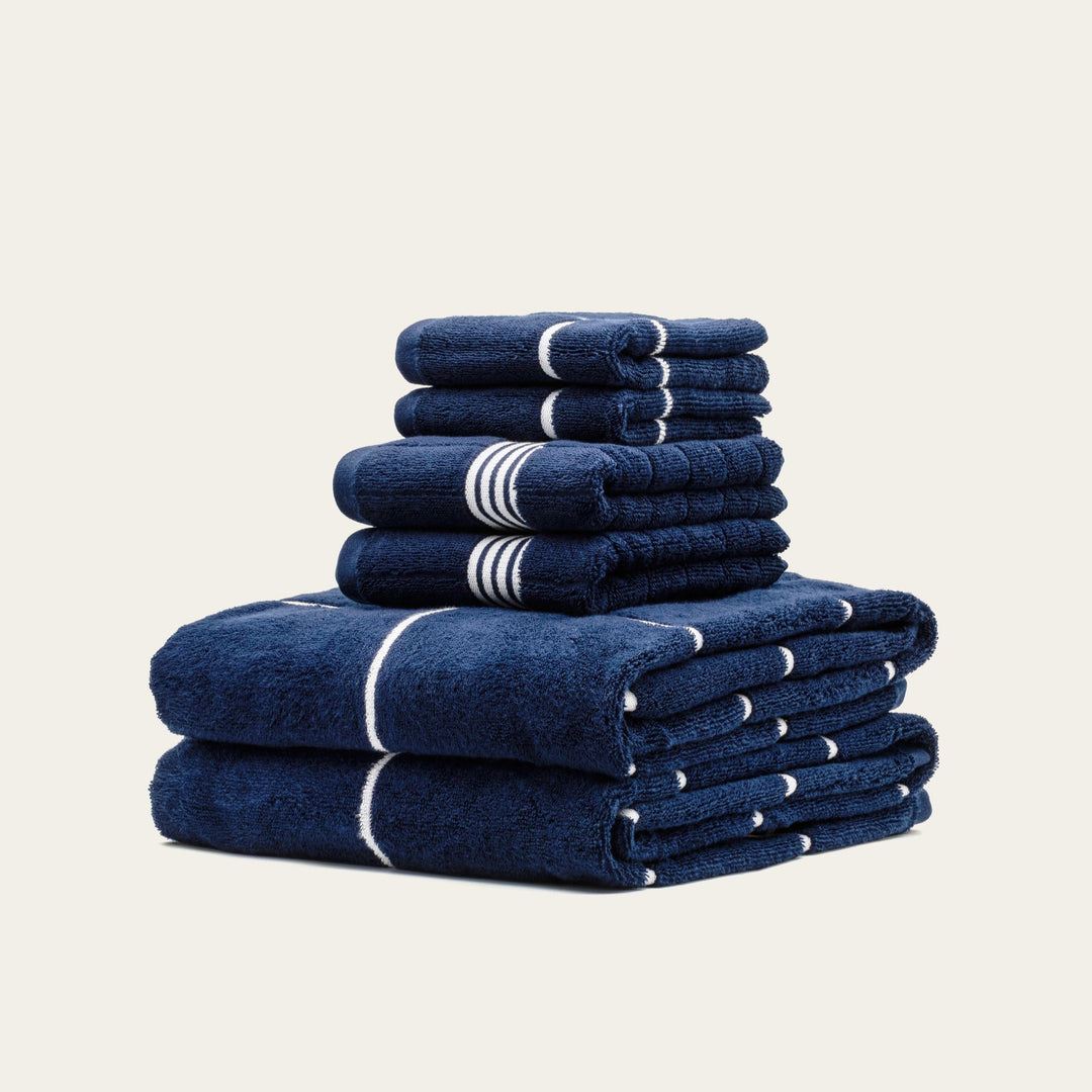 Stacked navy cotton towels with white stripe bands