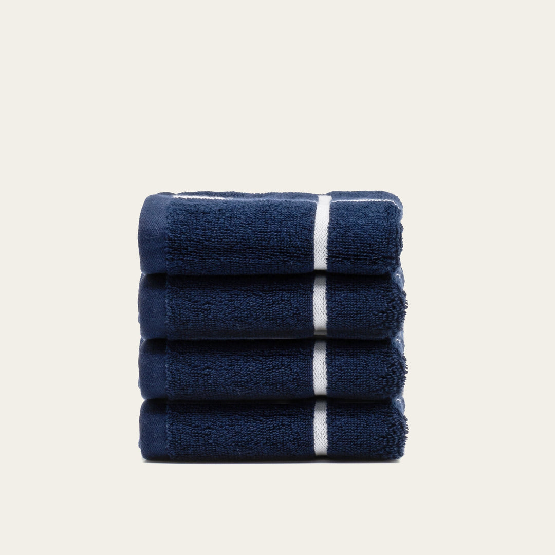Folded navy cotton towels with white stripe banding