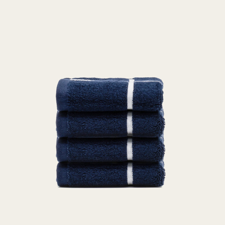 Folded navy cotton towels with white stripe banding