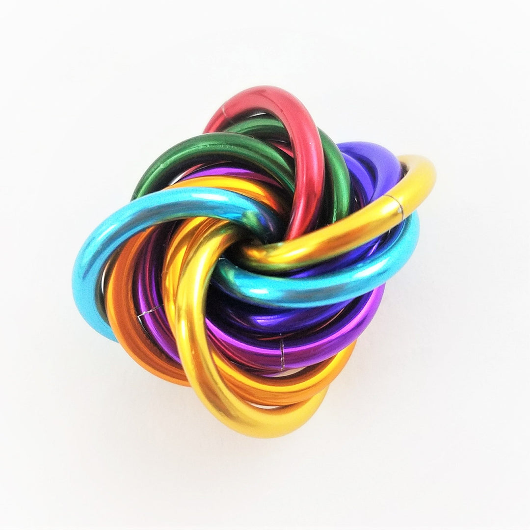 Shiny multicolor fidget stress ball with interlocking rainbow metal rings.