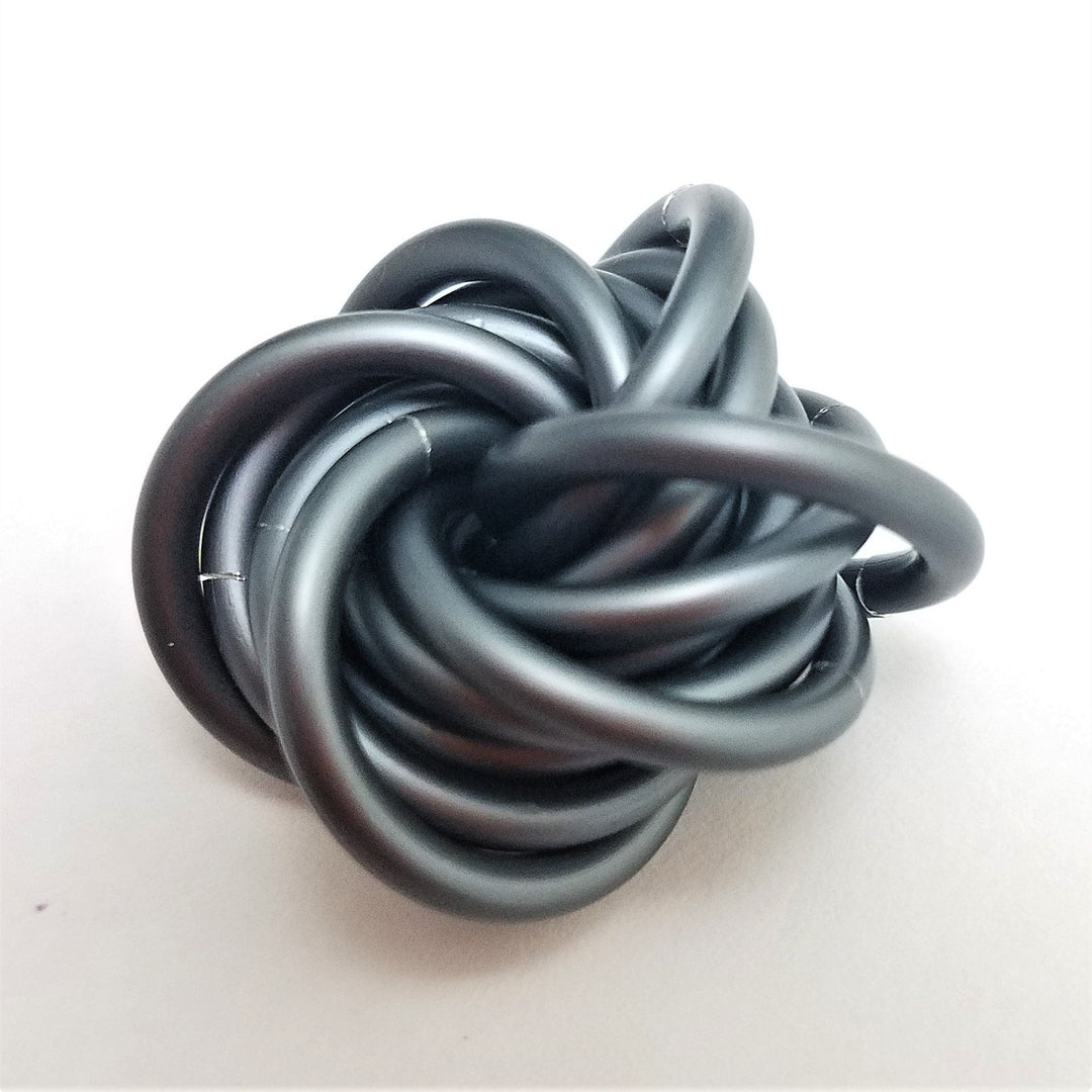 Gray stress fidget ball with twisted interlocking loop knot shape.