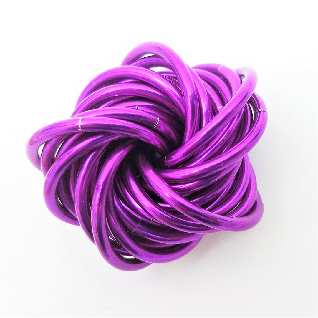 Magenta metallic twist fidget stress ball, knotted loop desk toy.