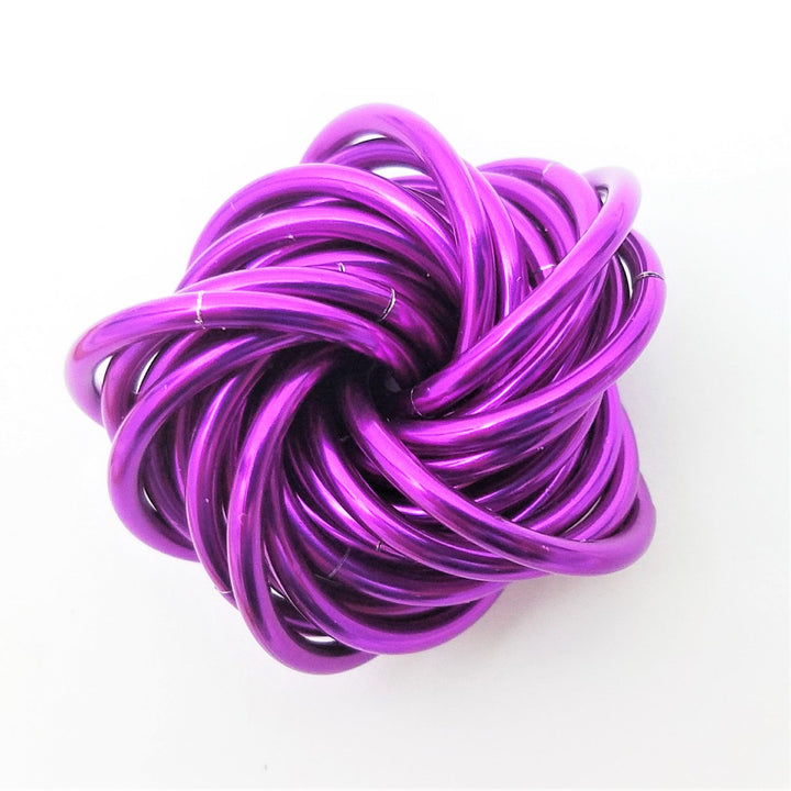 Magenta metallic twist fidget stress ball, knotted loop desk toy.