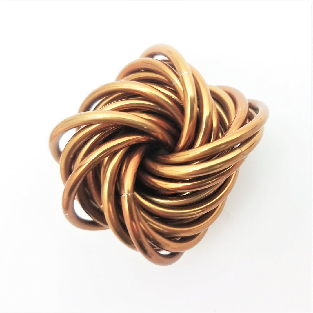 Shiny gold stress fidget ball with a twisted knot coil pattern.