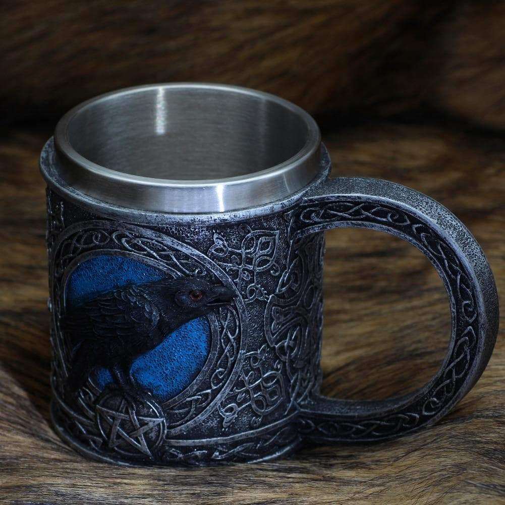 Stainless steel mug with raven-and-knot design, blue eye and markings, loop handle.