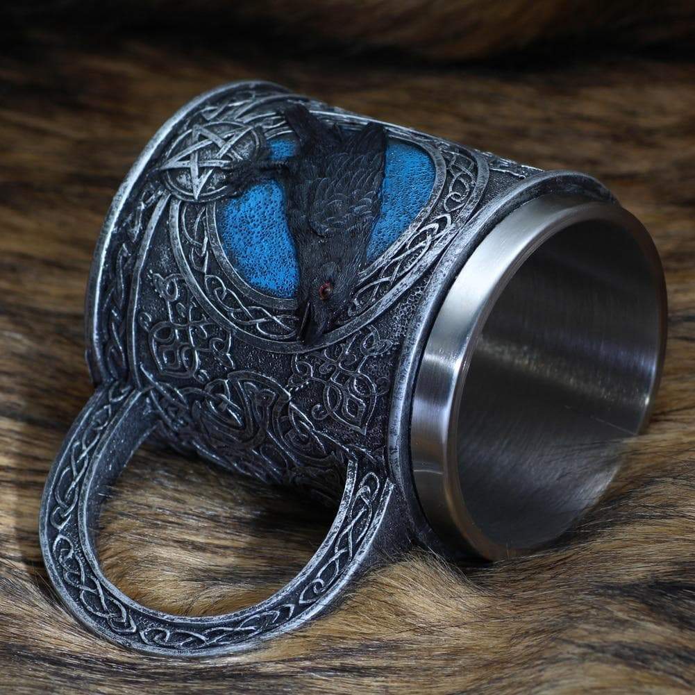 Stainless steel mug with raven relief panel, blue highlights, thick arched handle.