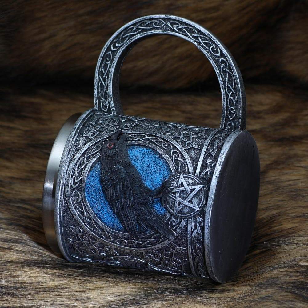 Stainless steel mug with raven relief on front, blue accents, top opening and handle.