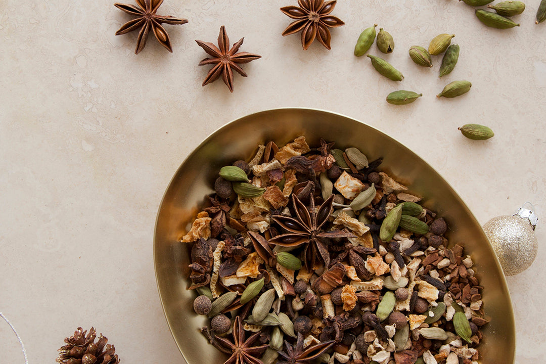 Bowl of dried mulling spices with star anise, citrus peel, and seeds