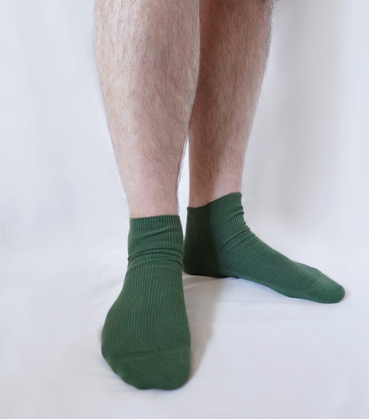 Men’s organic cotton crew socks in dark green worn with ribbed cuffs