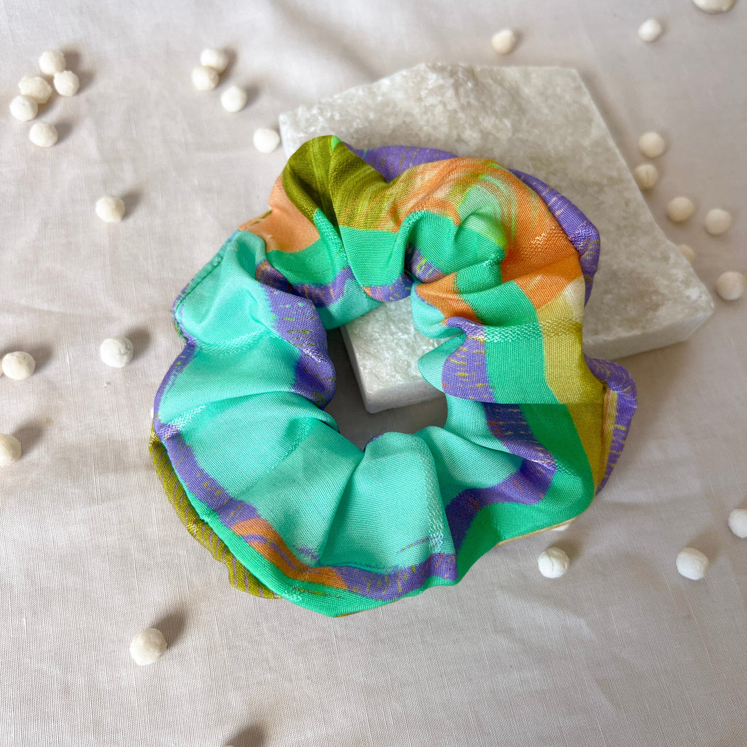 Turquoise scrunchie with purple, orange, and yellow striped fabric ruffle