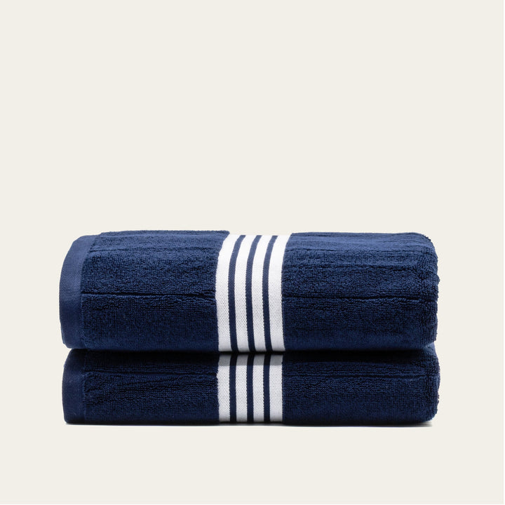 Navy cotton towel set with white striped bands, folded stack of 2 towels