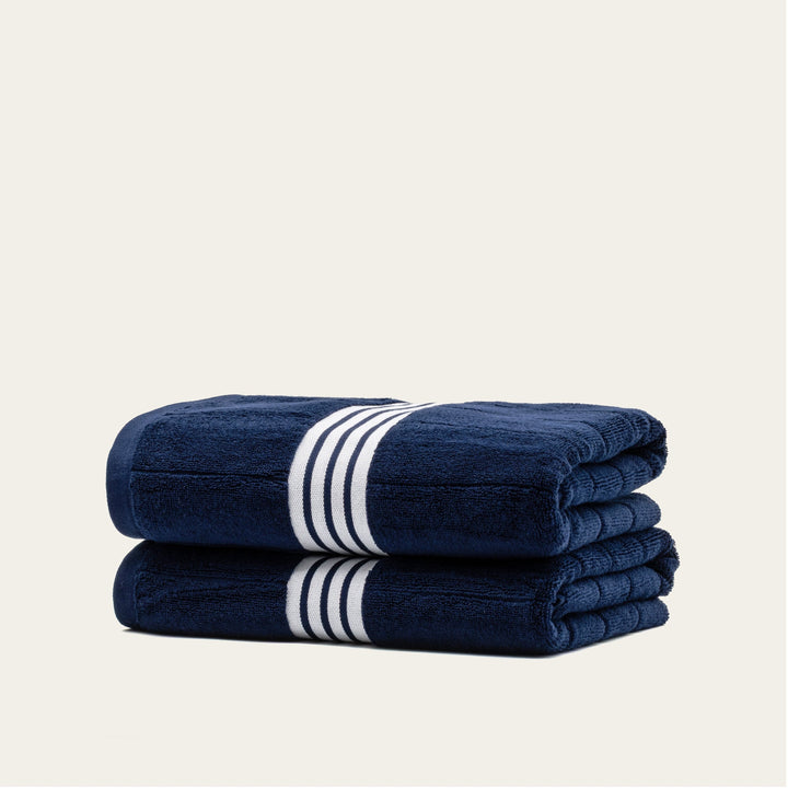 Navy cotton towels with white striped bands, folded stack of 2 towels