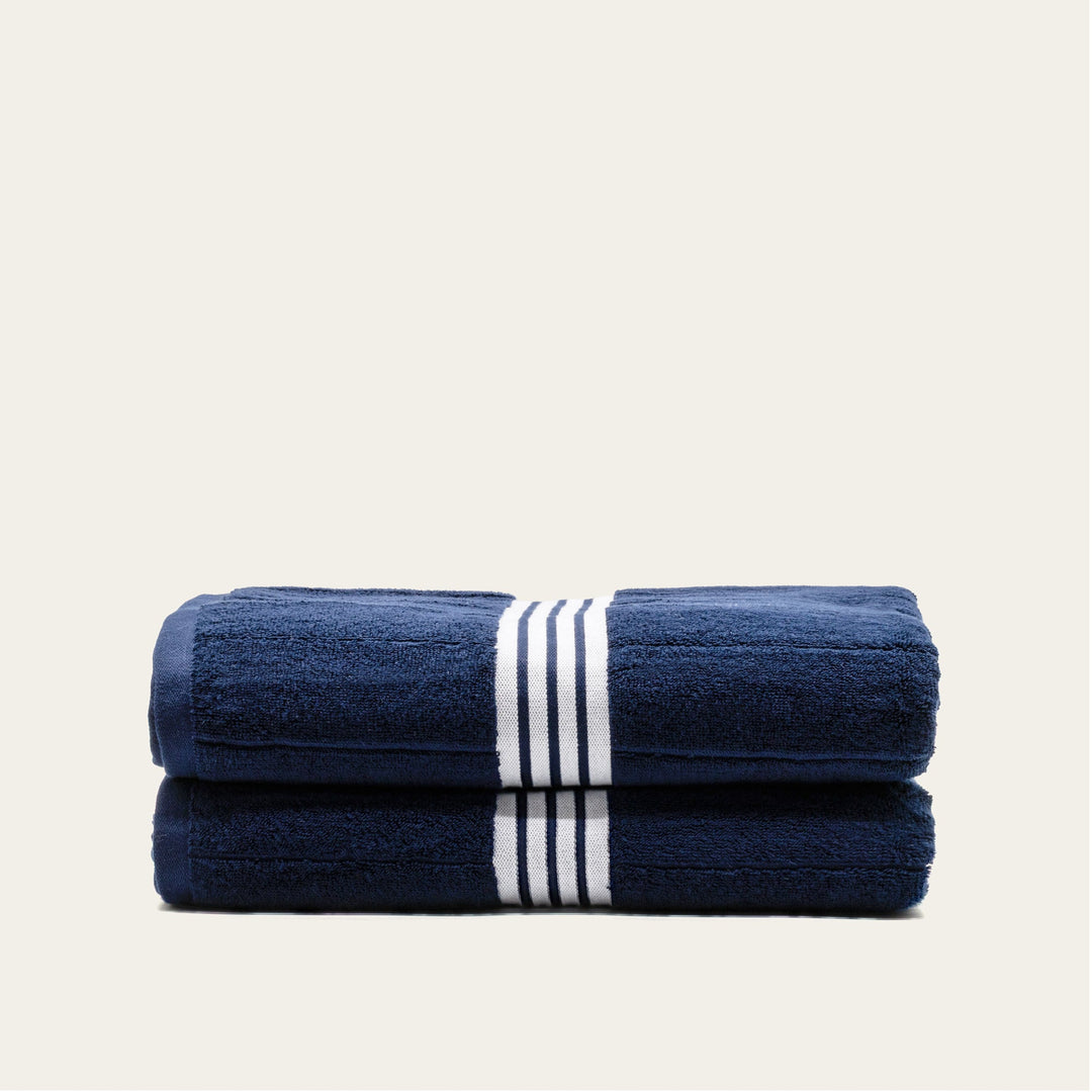 Navy cotton towels with white striped bands, folded stack of 2 towels