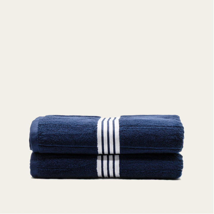 Navy cotton towels with white striped bands, folded stack of 2 towels