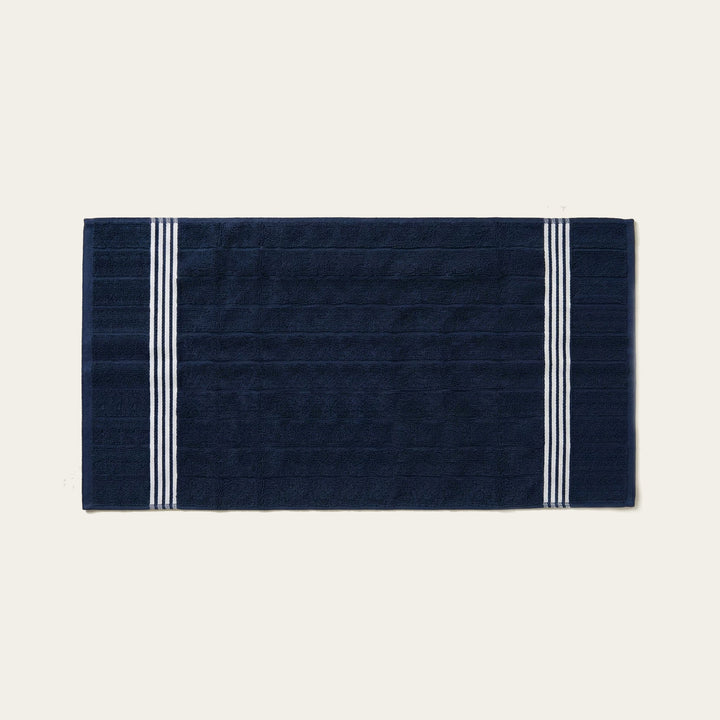 Navy cotton hand towel, flat with white twin stripe border at both sides