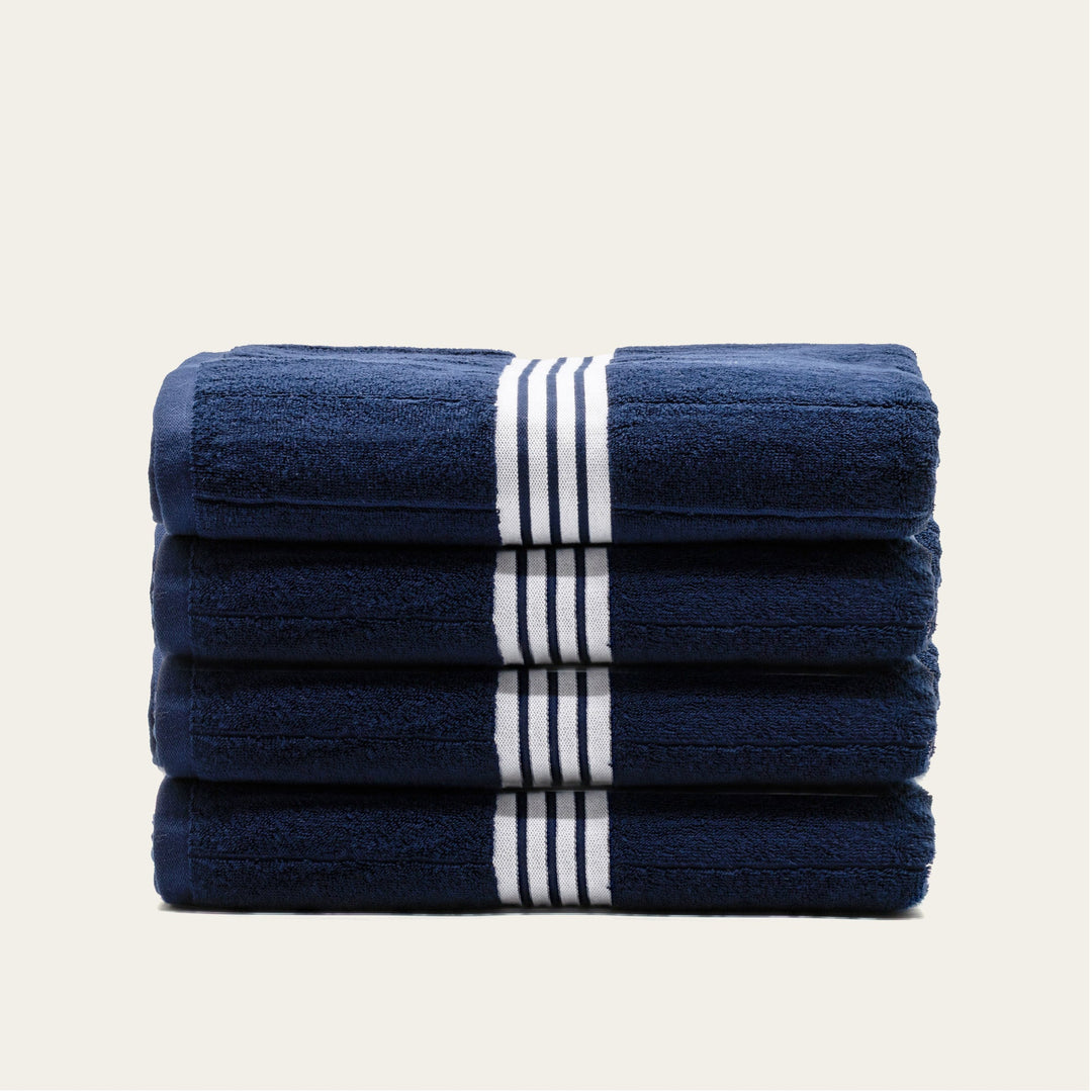 Stack of navy cotton towels with white striped bands