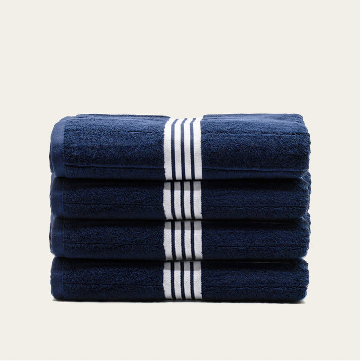 Stack of navy cotton towels with white striped bands