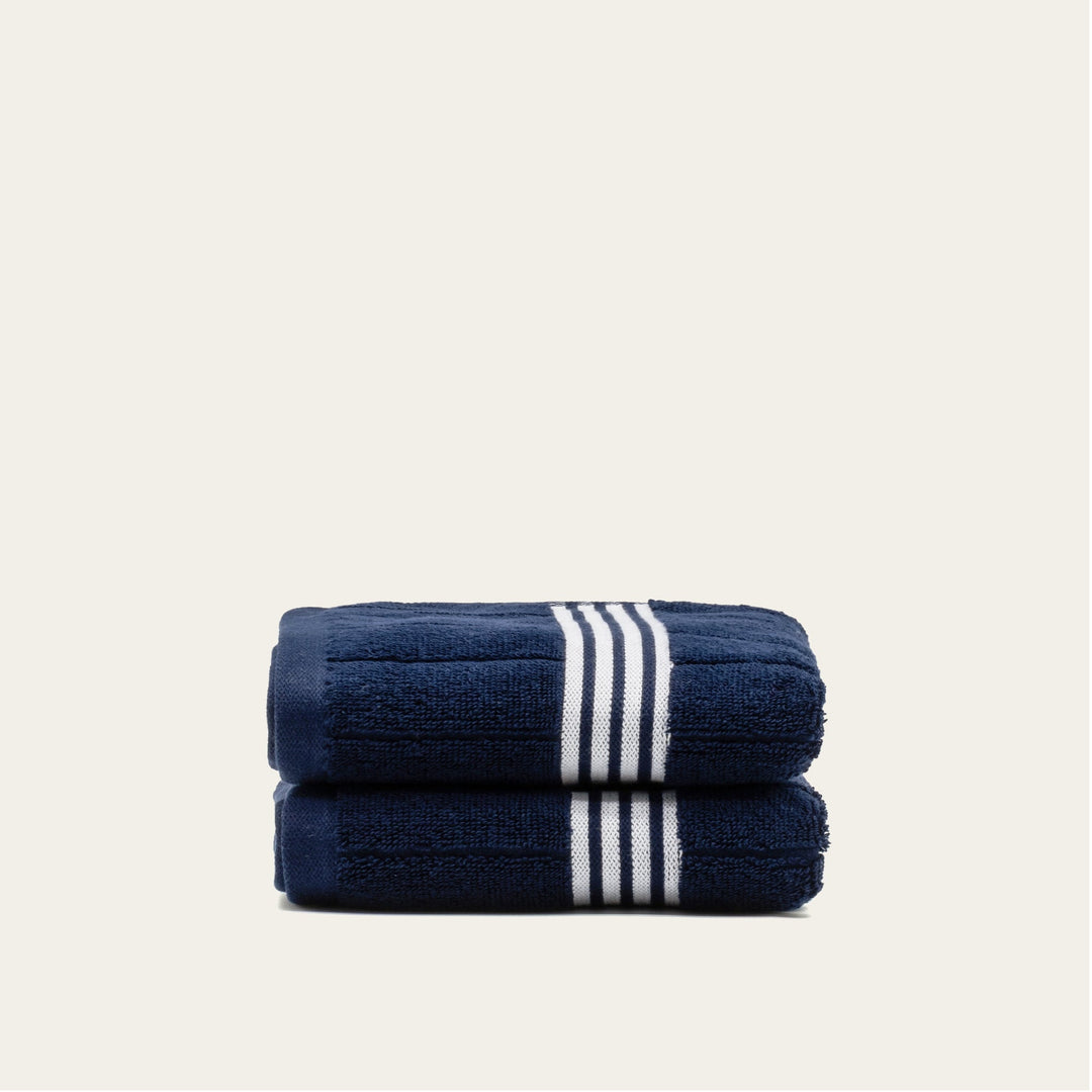 Navy cotton towel set with white striped bands, folded stack of 2 towels