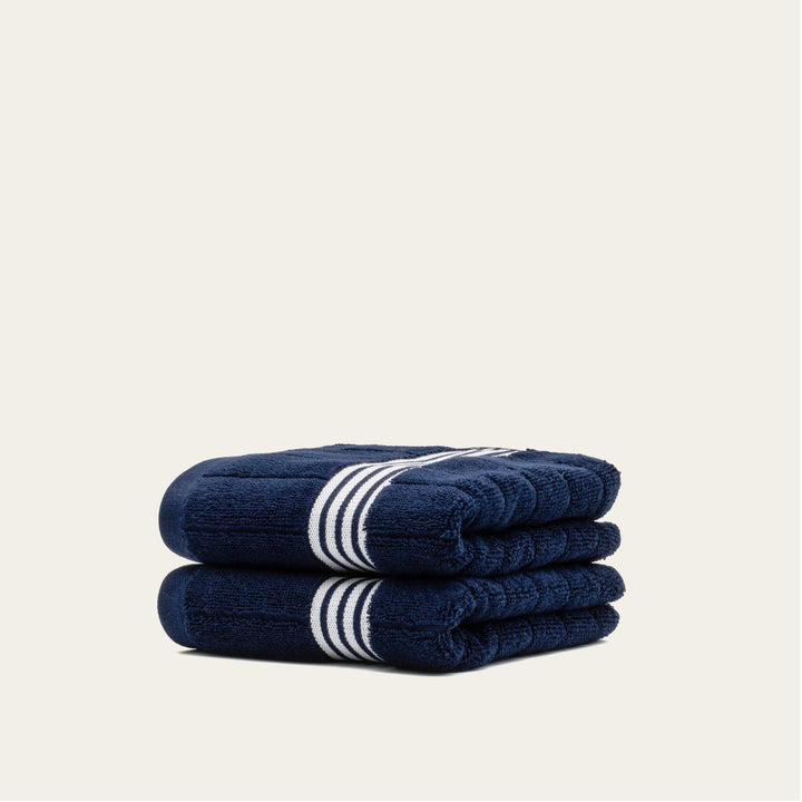 Navy cotton towels with white striped bands, folded stack of 2 towels