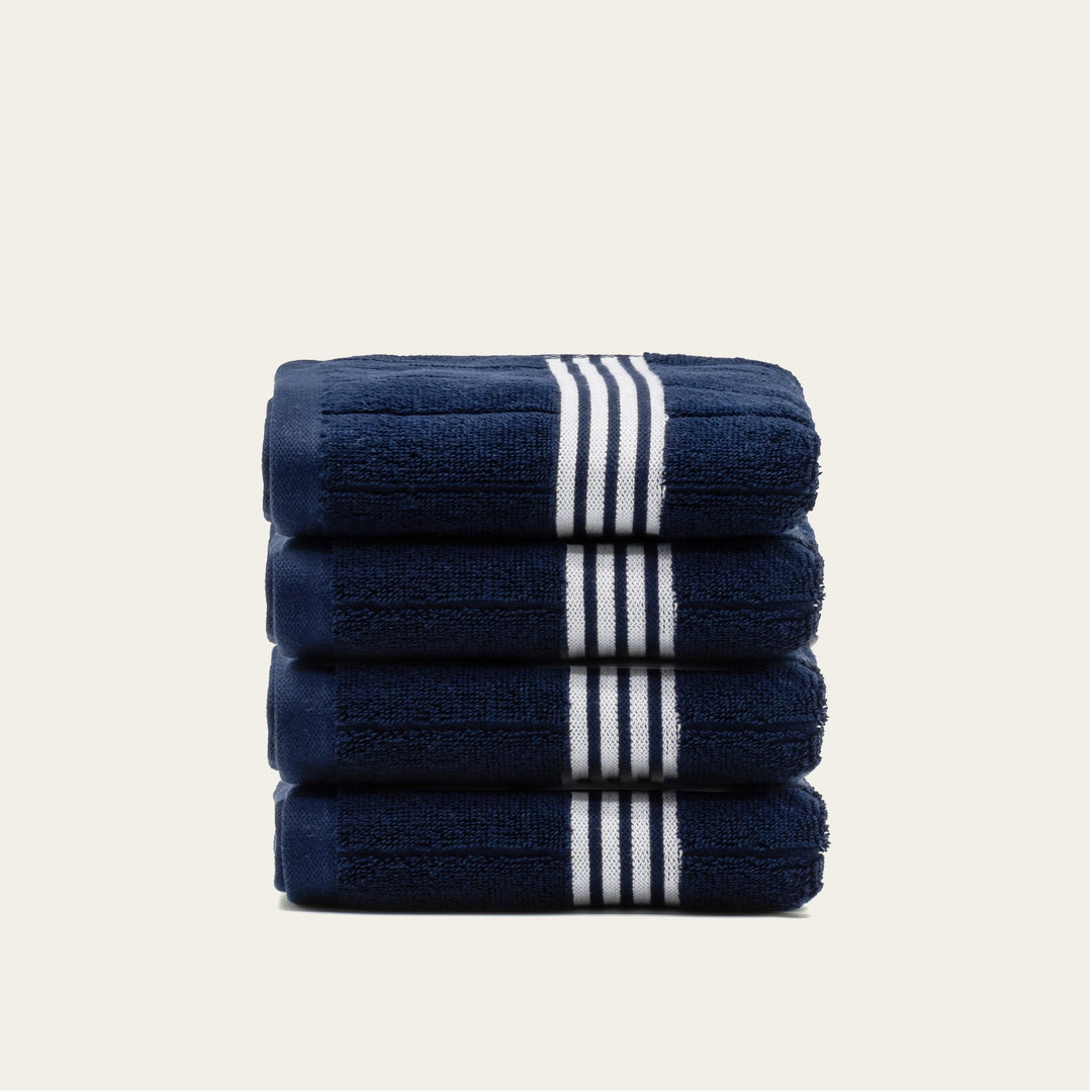Stack of navy cotton towels with white striped bands