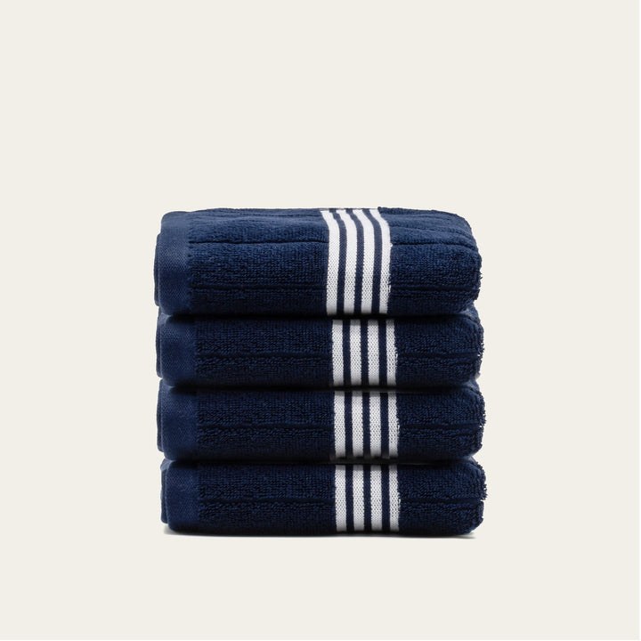 Stack of navy cotton towels with white striped bands