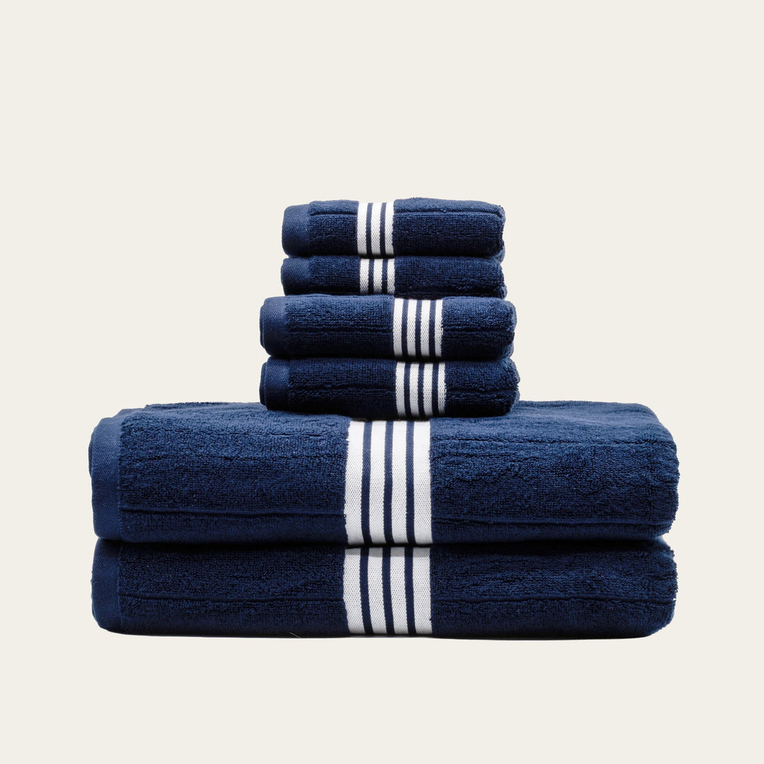 Navy cotton towel set with white striped bands, folded stack of 3 towels