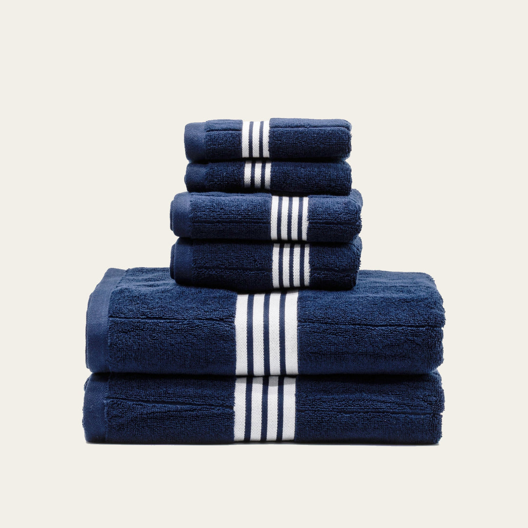 Folded navy cotton towels with white stripe bands in 3 layers