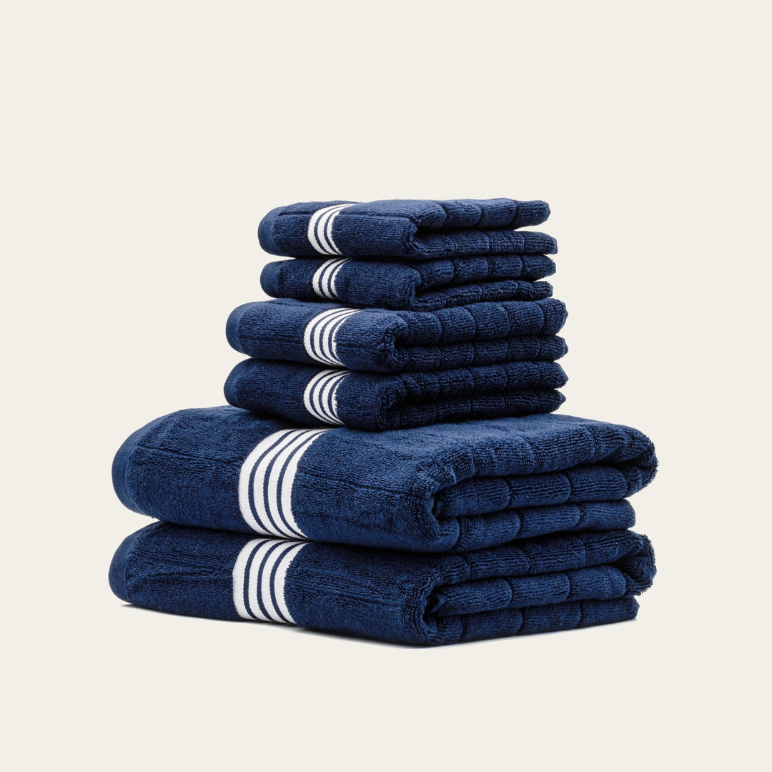 Stack of navy cotton towels with white striped bands