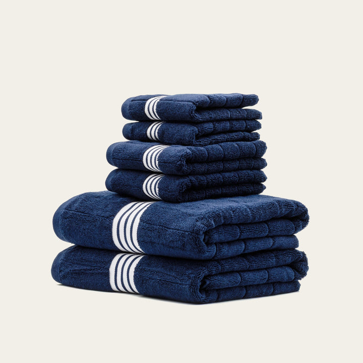 Stack of navy cotton towels with white striped bands
