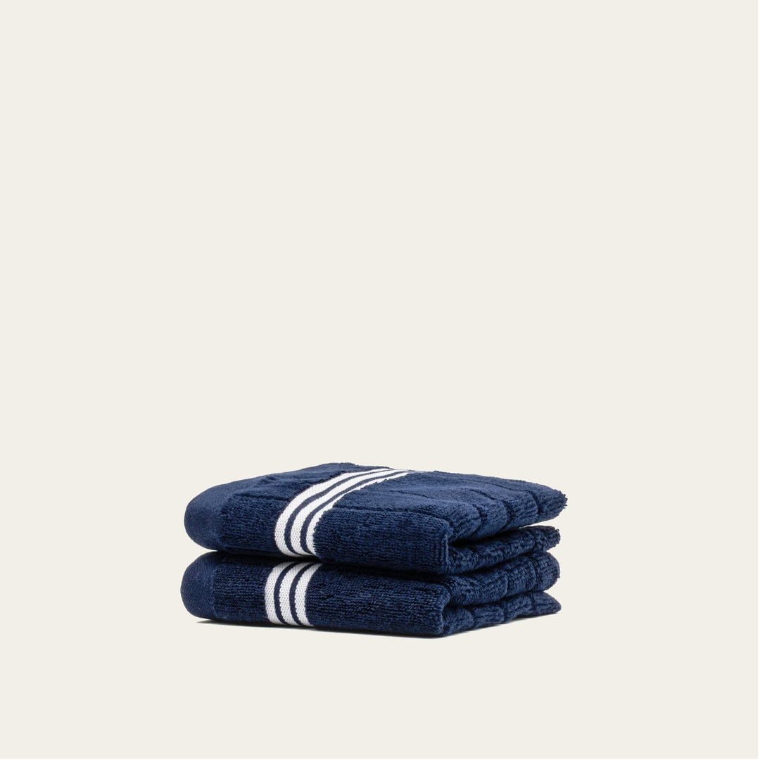 Navy cotton towels, folded stack with white striped bands