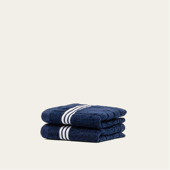 Navy cotton towels, folded stack with white striped bands