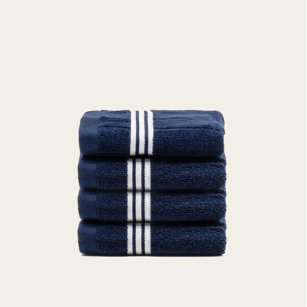 Stack of navy cotton towels with white striped bands