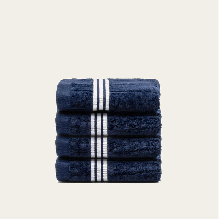 Stack of navy cotton towels with white striped bands