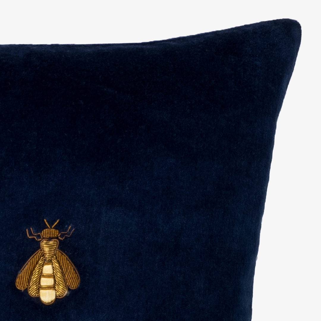 Navy velvet pillow cover corner with gold bee emblem patch