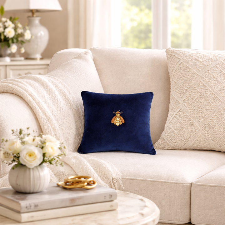 Navy velvet pillow cover with small gold bee embroidery on the front