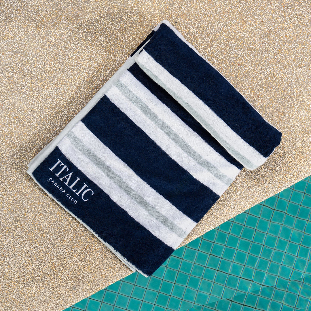 Cotton beach towel with navy and white horizontal stripes, ITALIC Caban Club logo