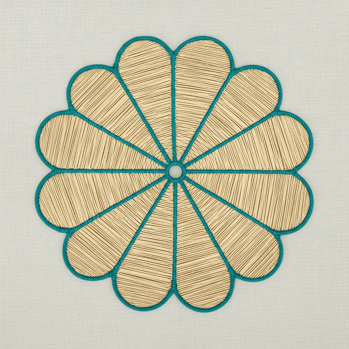 Handwoven iraca flower placemat with hot pink-stitched petals and a natural woven center.