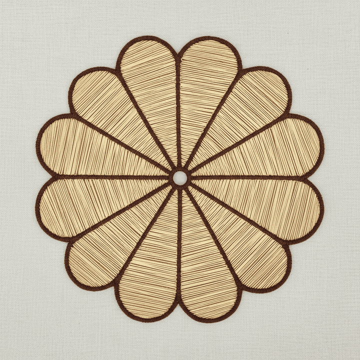 Handwoven iraca flower placemat with light green-stitched petals and a natural woven center.