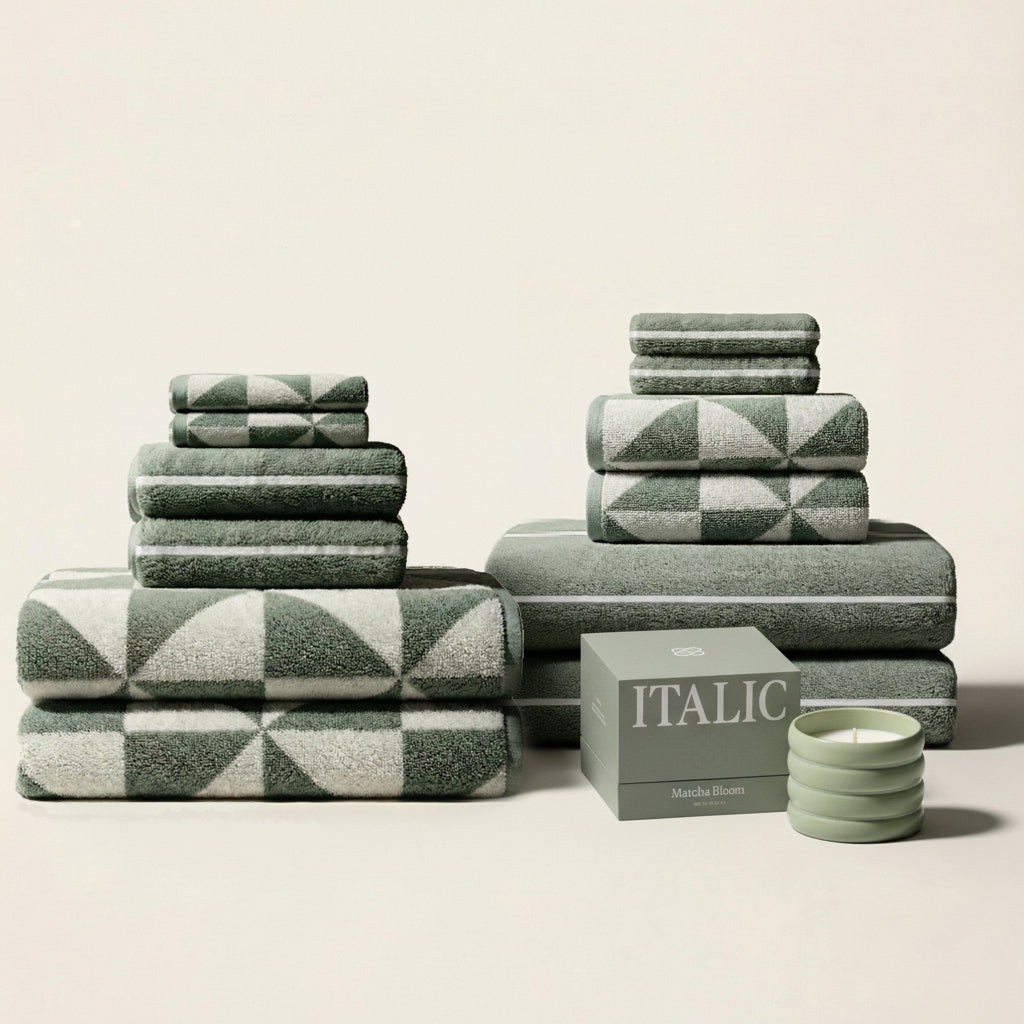 Stacked sage green and ecru cotton towels with plaid-style and striped designs