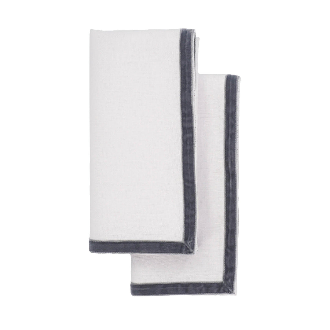Two linen napkins with dark velvet trim along edges, overlapping folds