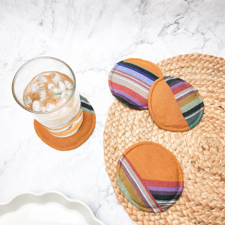 Circular woven coaster set; one woven straw coaster with three striped fabric coasters